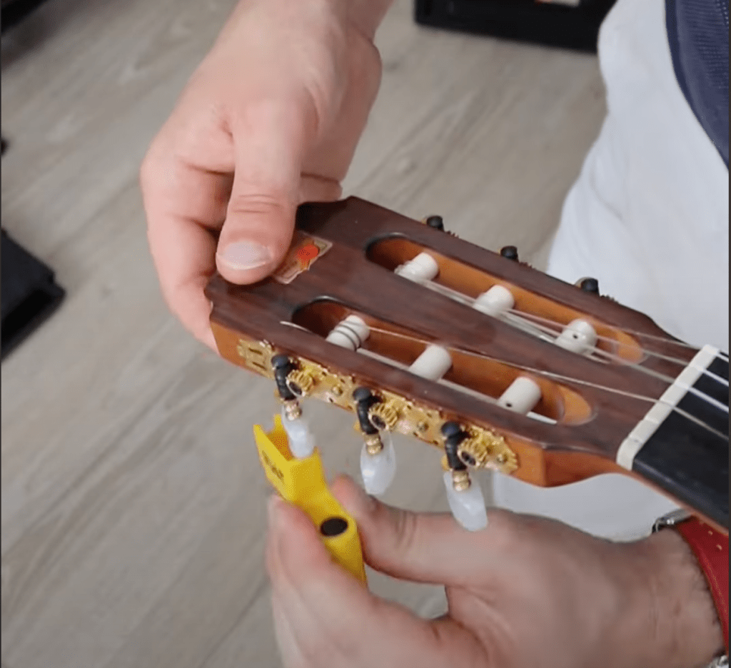 détente d'une corde de guitare à l'aide de la clé