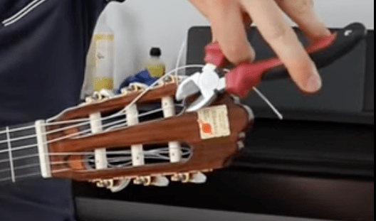 coupe du surplus de corde de guitare qui dépasse de la tête