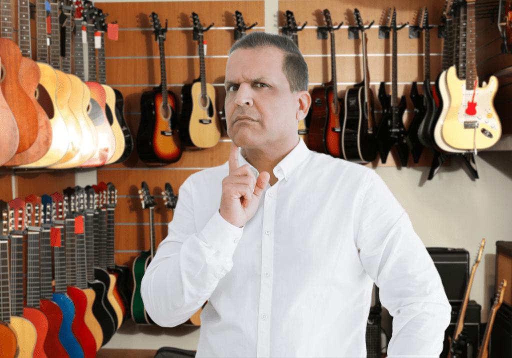 Homme qui réfléchit dans un magasin de guitares