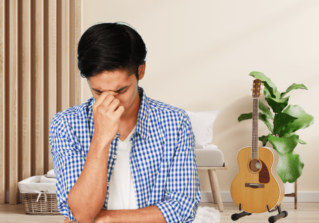homme découragé debout à côté de sa guitare