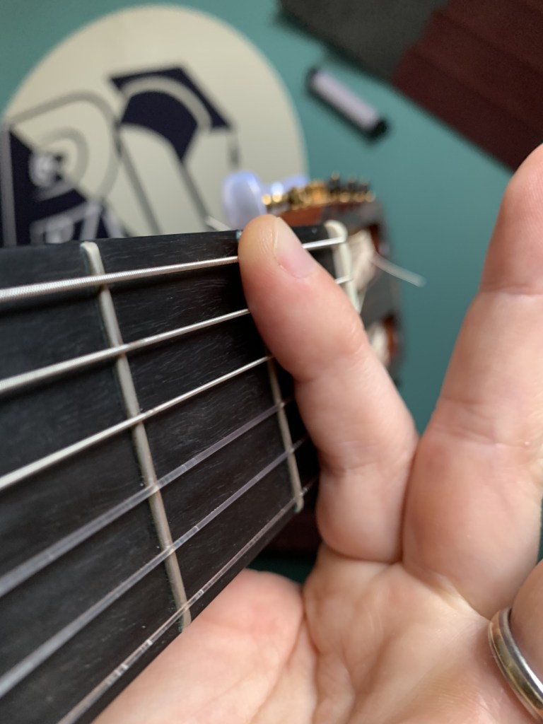 position de l'index sur le manche de la guitare pour un accord barré 